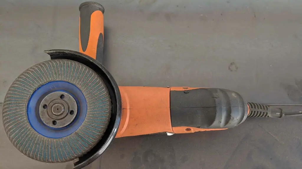 A photo of an angle grinder with an attached flap disk